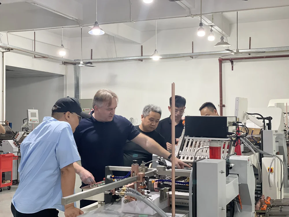 Client and engineer discussing automatic buckle folding machine in SPEED Machinery workshop