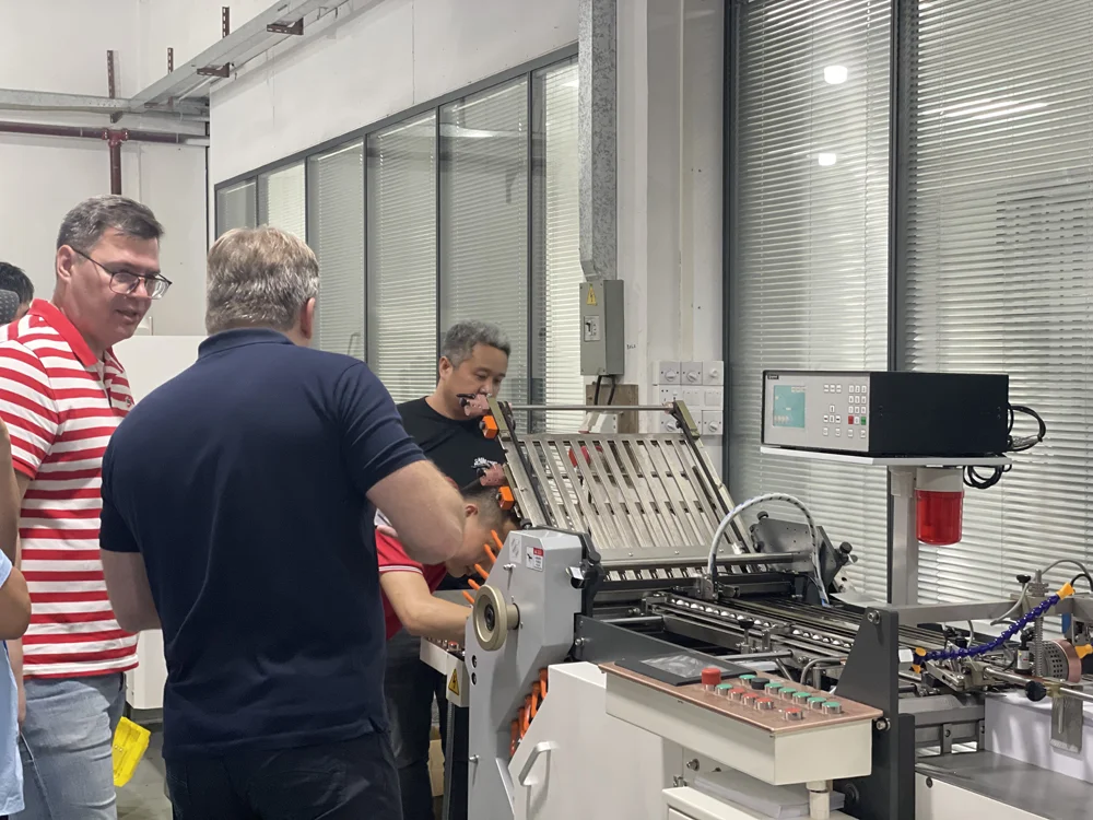 Client watching live demo of high-speed paper folding machine production line